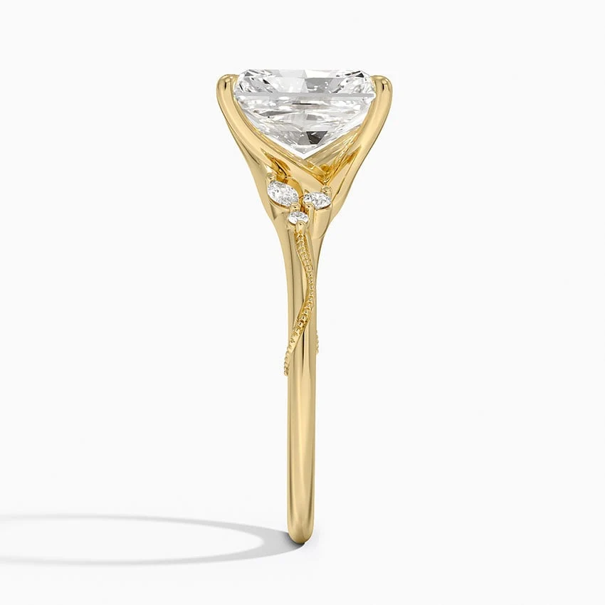 Yellow gold radiant cut moissanite engagement ring direct side profile view showing milgrain vine band and cluster side accents