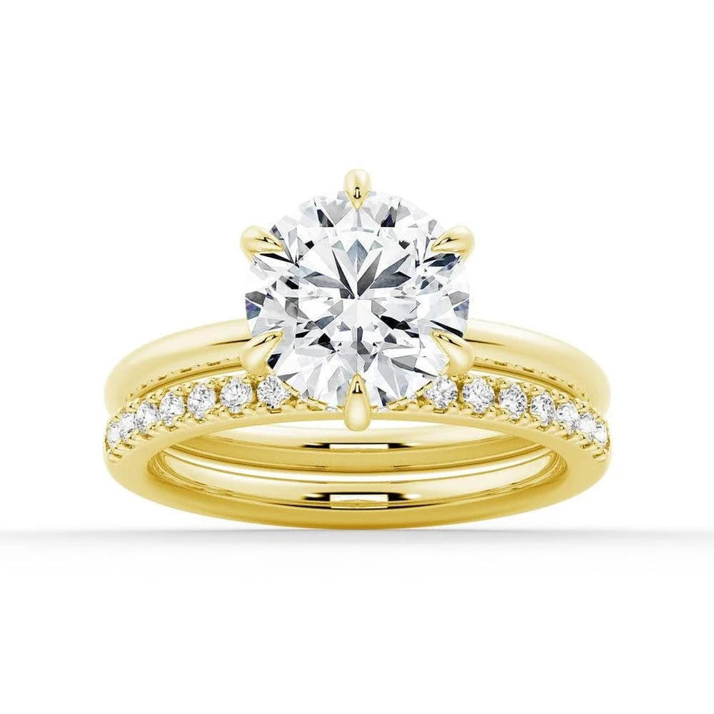 Yellow gold round moissanite bridal set with six-prong solitaire and pave wedding band