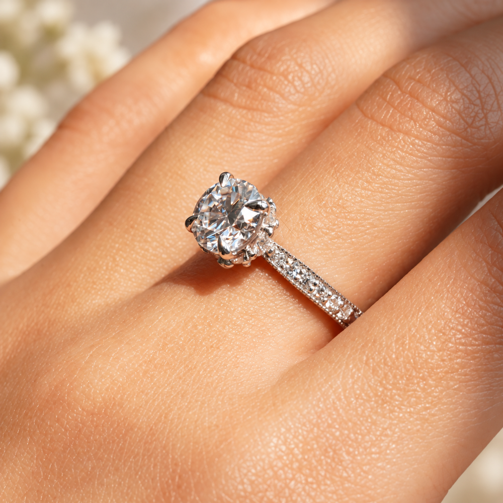 On-hand perspective view of round moissanite ring showing hidden halo collar and milgrain pave band