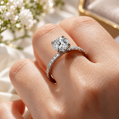 Perspective angle view of round cut moissanite engagement ring with pave setting on hand