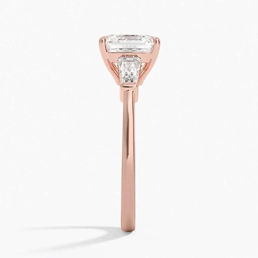 Rose gold asscher cut moissanite three-stone engagement ring direct side profile view showing bar set side stones