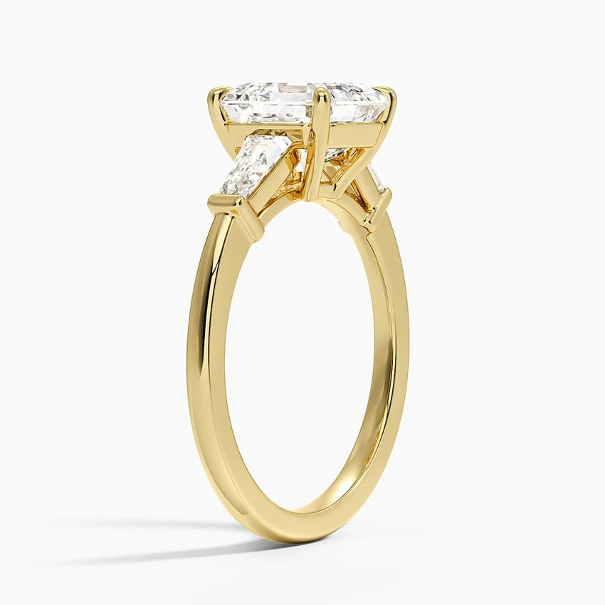 Yellow gold asscher cut moissanite three-stone engagement ring 3/4 side perspective view showing claw prongs