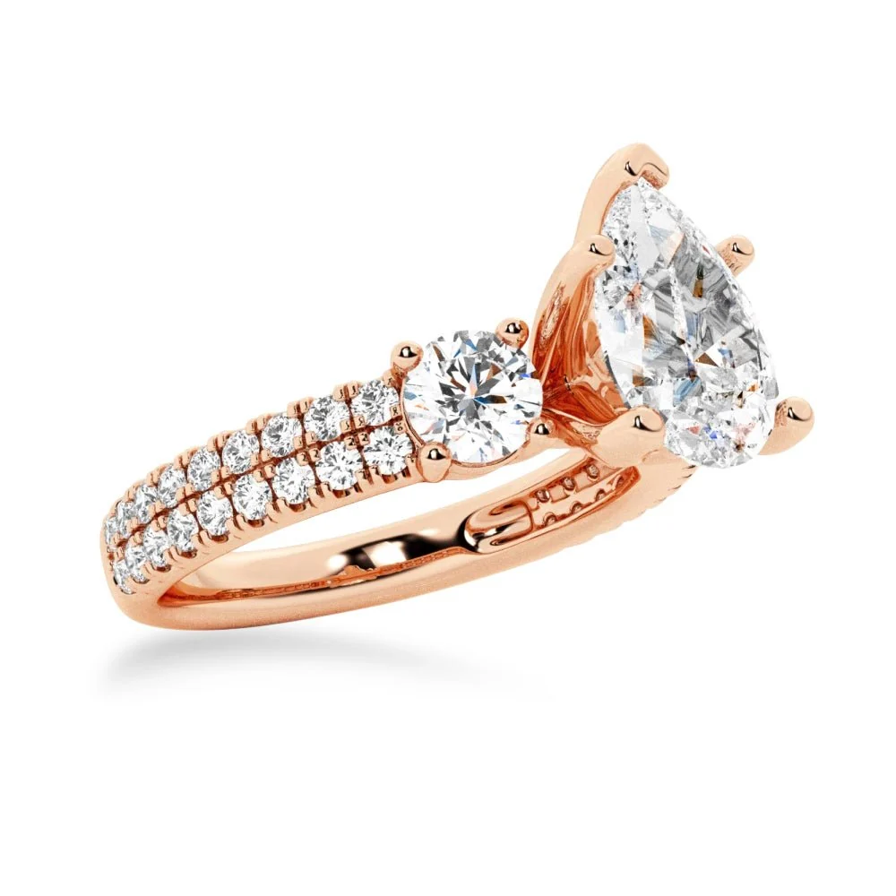 Rose gold three stone pear moissanite engagement ring 3/4 angle view showcasing side accent gems
