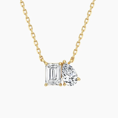 Yellow gold Toi et Moi emerald cut and pear moissanite two stone pendant necklace top view