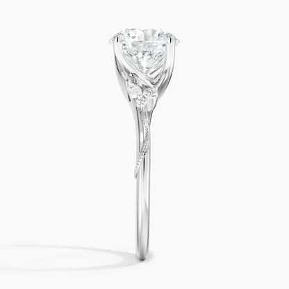 Side view showing intricate vine detail and marquise cluster on white gold round moissanite ring